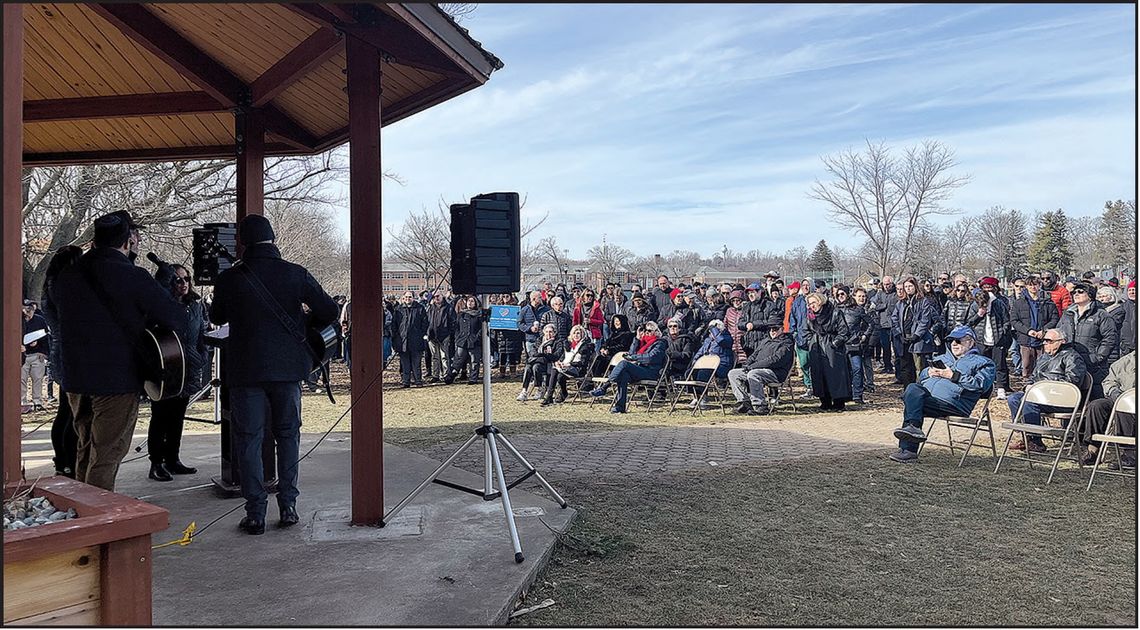 Above, event’s organizers initiated a collective singing of prayer songs. Below, protester Stacey Abenstein holds a sign that reads, “Hate has no home here.”